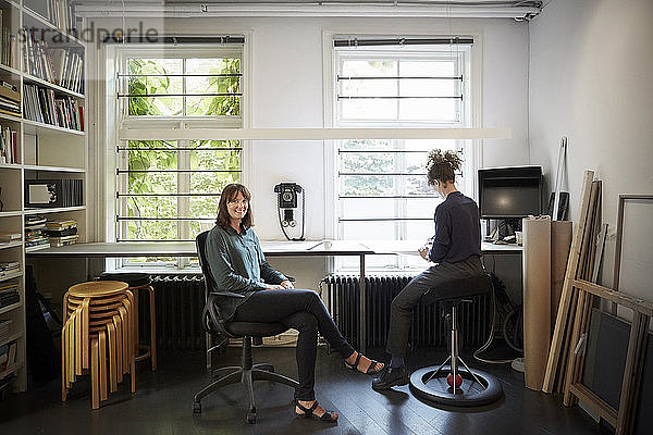 Porträt einer Architektin mit Tischmitarbeiterin im Büro