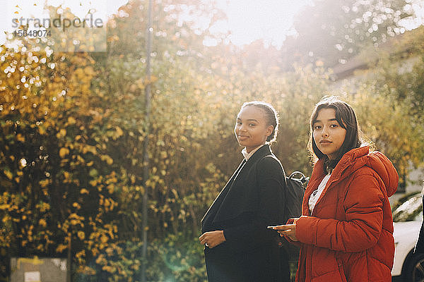 Porträt von Teenager-Mädchen in Jacke an Bäumen im Herbst