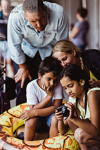 Mädchen zeigt der Familie eine Kamera  während sie am Bahnsteig des Bahnhofs wartet
