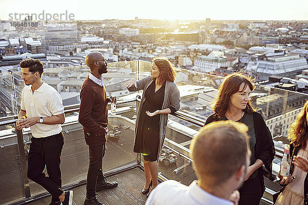 Geschäftskollegen diskutieren auf der Terrasse bei der After-Work-Party