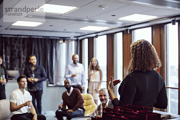 Geschäftsfrau hält Rede vor Mitarbeitern während Büroparty nach der Arbeit
