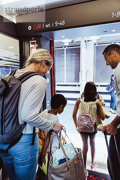 Familie mit Gepäck steigt gemeinsam aus dem Zug