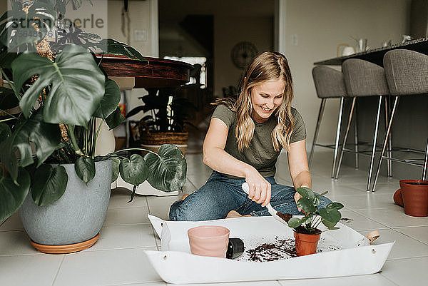 Frau beim Umtopfen von Zimmerpflanzen