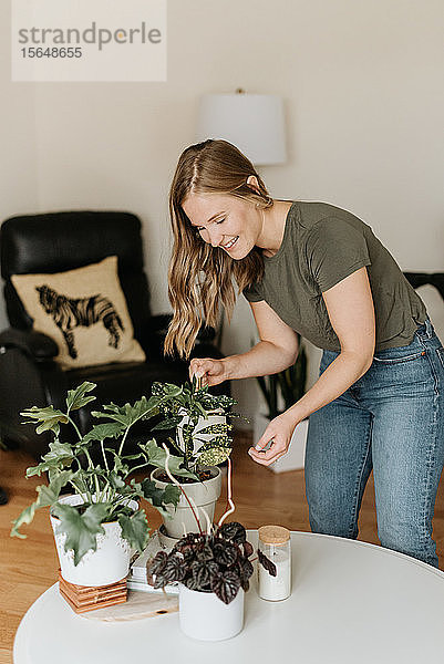 Frau gießt Zimmerpflanzen