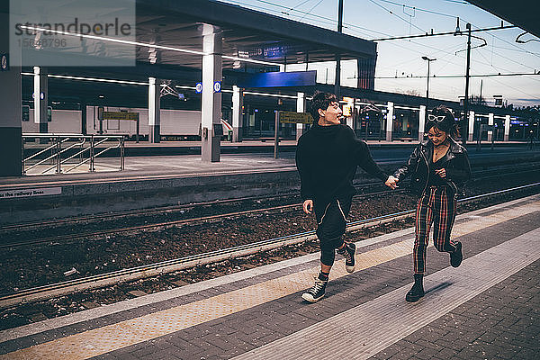 Junges Paar rennt auf dem Bahnsteig im Bahnhof  Mailand  Italien