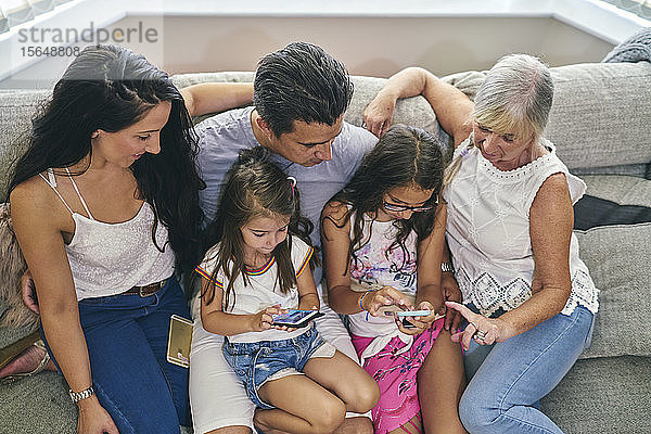 Drei-Generationen-Familie genießt Computerspiele auf dem Sofa