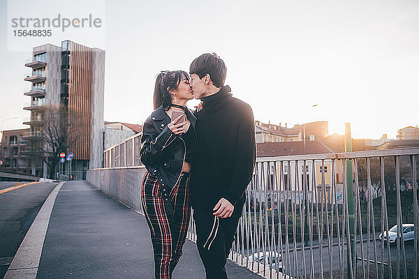 Trendiges Paar küsst sich auf der Brücke  Mailand  Italien