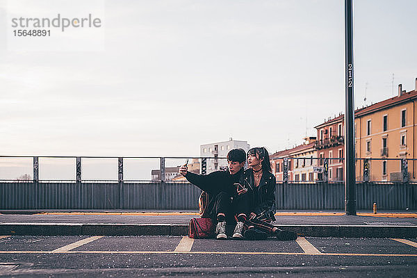 Junges Paar  das sich auf dem Bordstein vergnügt  Mailand  Italien