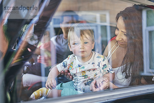 Ehepaar mit Kindern im Auto sitzend