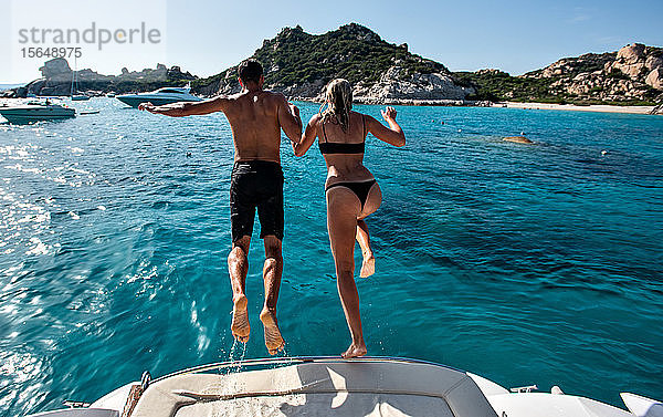 Junges Paar springt von einer Yacht ins Meer  Insel La Maddalena  Sardinien  Italien