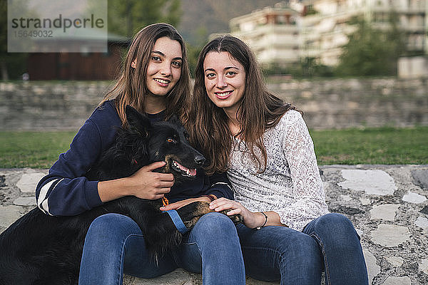 Schwestern mit Hund im Park