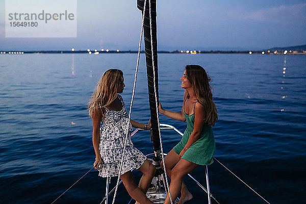 Freunde entspannen abends auf einem Segelboot  Italien