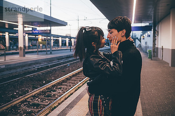 Zärtliches junges Paar auf dem Bahnsteig des Bahnhofs  Mailand  Italien