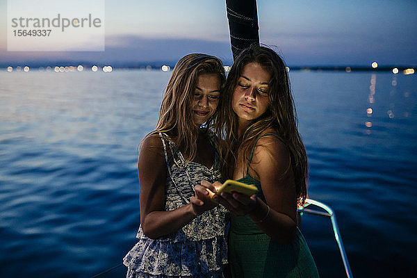 Freunde auf einem Segelboot  Textnachrichten austauschen  Italien