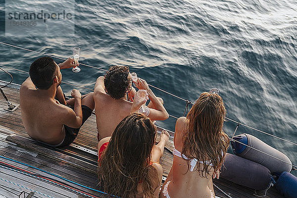 Freunde genießen Champagner auf einem Segelboot  Italien