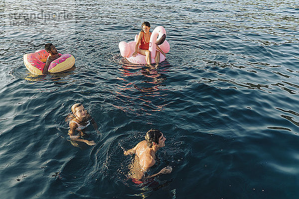 Freunde schwimmen und entspannen auf Schwimmern auf dem Meer  Italien