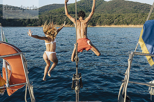 Freunde springen vom Segelboot ins Meer  Italien