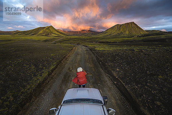 Reisende  die im Fahrzeug einen malerischen Blick auf die Vulkanberge genießt  Landmannalaugar  Hochland  Island