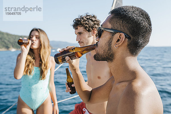 Freunde genießen Bier auf einem Segelboot  Italien