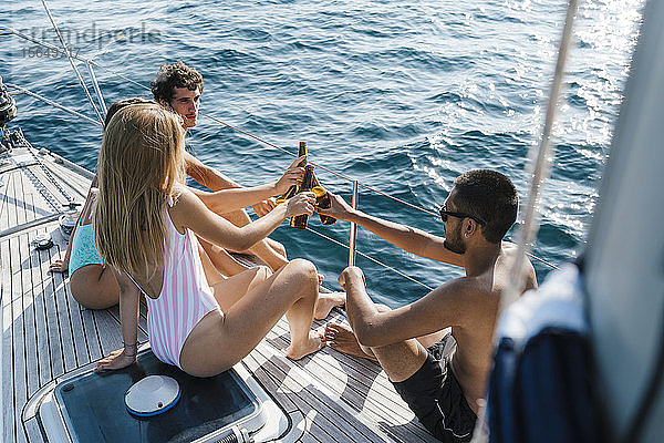 Freunde stoßen mit Bier auf dem Segelboot an  Italien