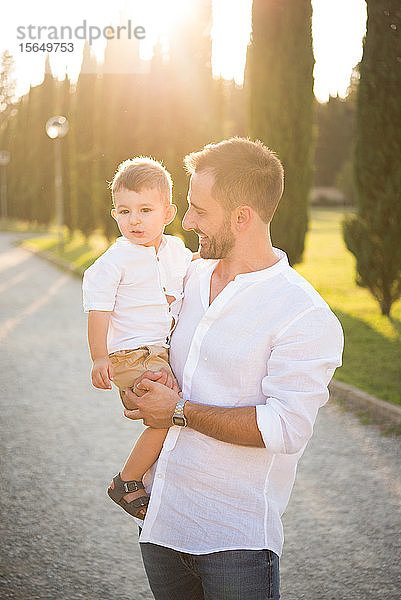 Vater trägt Sohn im Park