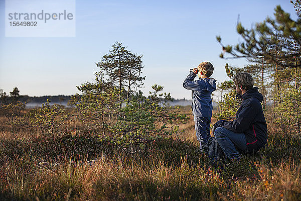 Vater und Sohn erkunden Wald  Finnland