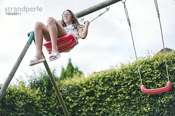 Mädchen auf Schaukel im Garten