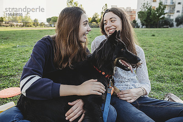 Schwestern mit Hund reden im Park