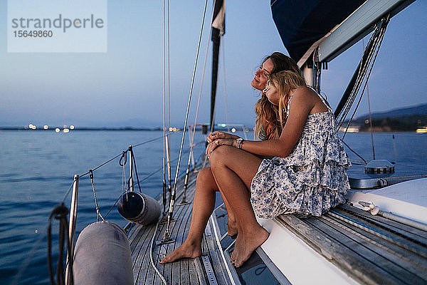 Enge Freunde entspannen abends auf einem Segelboot  Italien