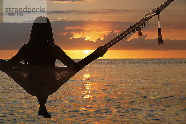 Frau in Hängematte sitzend bei Sonnenuntergang am Miami Beach in Miami  Florida  USA