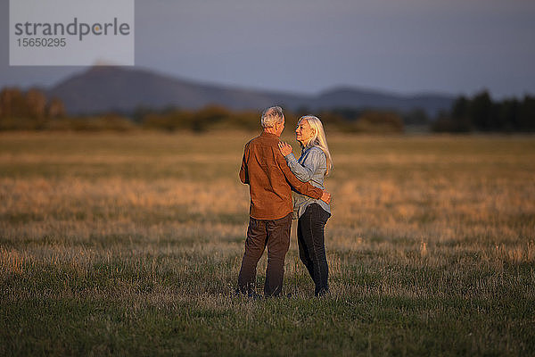 Ehepaar im Feld bei Sonnenuntergang in Picabo  Idaho  USA
