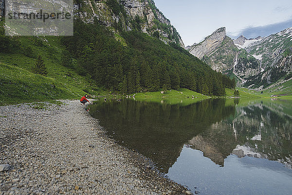 Frau hockt am Seealpsee in den Appenzeller Alpen  Schweiz
