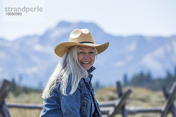 Frau mit Cowboyhut am Holzzaun in Stanley  Idaho  USA