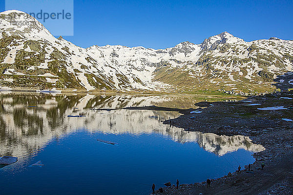 Fischer am Ufer des Montesplugasees in der Morgendämmerung  Valchiavenna  Valle Spluga  Provinz Sondrio  Valtellina  Lombardei  Italien