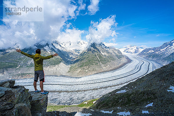 Jubelnder Mann mit ausgestreckten Armen mit Blick auf den Aletschgletscher vom Aussichtspunkt Eggishorn  Berner Alpen  Kanton Wallis  Schweiz