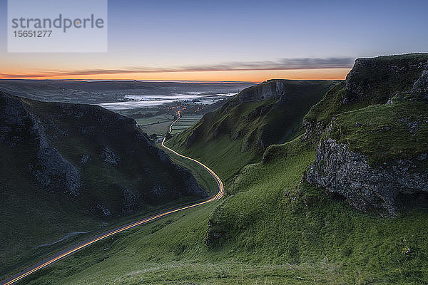 Winnats Pass bei Sonnenaufgang mit Auto-Lichtspuren  Winnats Pass  Hope Valley  Peak District  Derbyshire  England  Vereinigtes Königreich