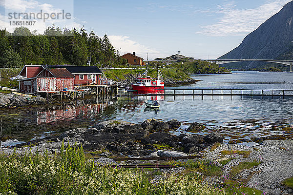 Ein Fischerboot und Dockhäuser in der Nähe der Kakernbrücke  Ramberg  Lofoten  Norwegen