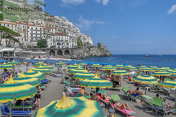 Strandansicht mit Badegästen und bunten Sonnenschirmen vor niedrigen Gebäuden  Amalfi-Stadt  Costiera Amalfitana  UNESCO-Weltkulturerbe  Kampanien  Italien  Europa