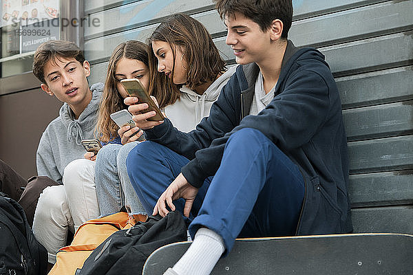 Freunde benutzen ihr Smartphone im Freien