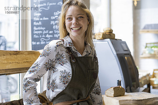 Lächelnde junge Frau in einem Lebensmittelladen stehend