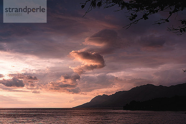 Blick auf Meer und Berge gegen bewölkten Himmel