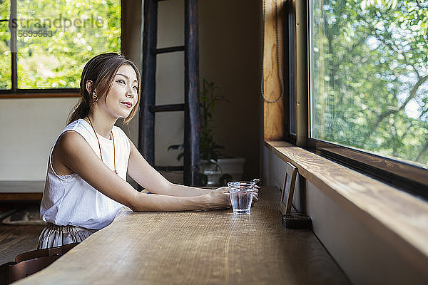 Japanerin  die an einem Tisch in einem japanischen Restaurant sitzt.