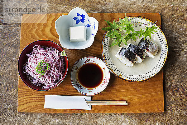Hochauflösende Nahaufnahme von Sushi  Tofu  Nudeln und Sojasauce auf einem Tisch in einem japanischen Restaurant.