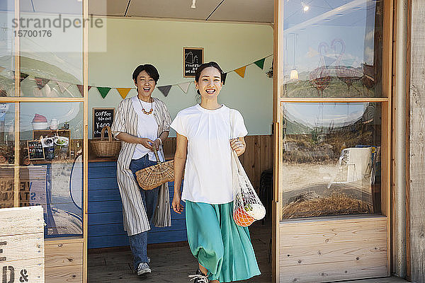 Zwei lächelnde Japanerinnen verlassen den Hofladen.