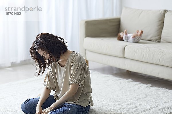 Unglückliche japanische Mutter mit neugeborenem Baby