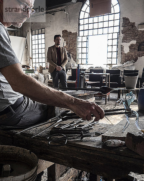 Italien  Venetien  Venedig  Insel Murano  Glasbläserkunst aus Murano  ein Handwerker bei der Glasbearbeitung in einer traditionellen Glashütte