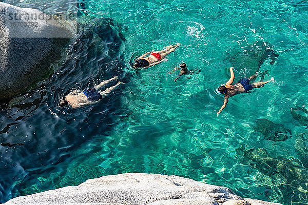 Vierköpfige Familie schwimmt im kristallklaren Meer  Cagliari  Sardinien