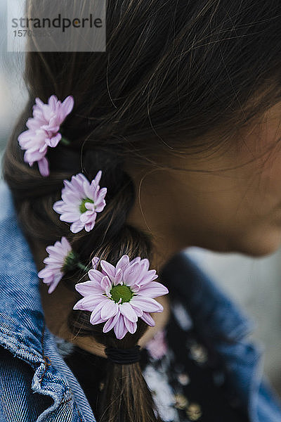 Close up Frau mit lila Blumen im geflochtenen Haar