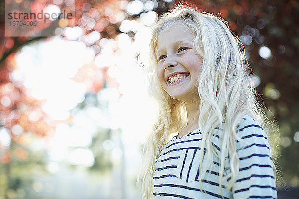 Selbstbewusstes  glückliches Mädchen lächelnd im Herbstpark