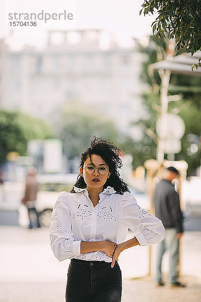 Porträt selbstbewusste  stilvolle Frau auf dem Bürgersteig